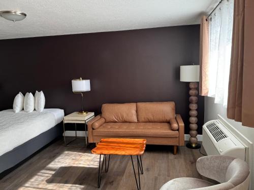 a bedroom with a bed and a couch and a table at Bridge Street Inn in Baker City