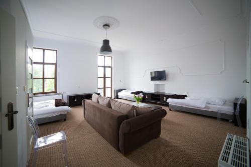 salon z kanapą, stołem i oknami w obiekcie OperaHostel w Bydgoszczy
