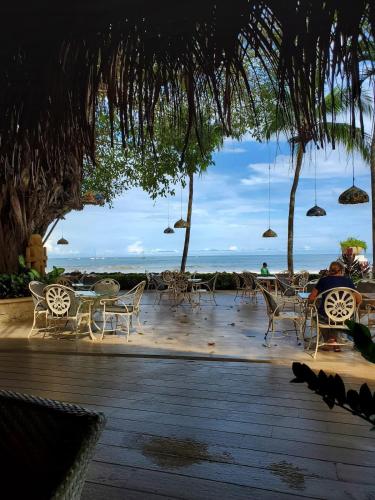 a patio with chairs and tables and the ocean at Matapalo Diria #504 Amazing Condo-Ocean View in Tamarindo