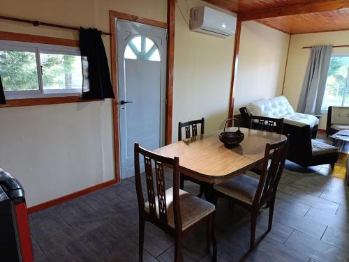 a living room with a wooden table and chairs at Cabañas Hamdan villa residencial laguna brava in Balcarce