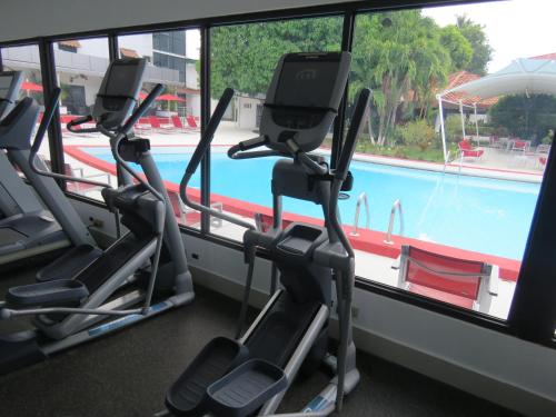 a gym with three treadmill machines next to a swimming pool at Gran Hotel Nacional in David
