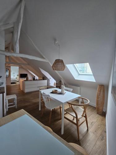 une salle à manger blanche avec une table et des chaises dans l'établissement Santorin, Appartement lumineux au coeur de Vannes, à Vannes