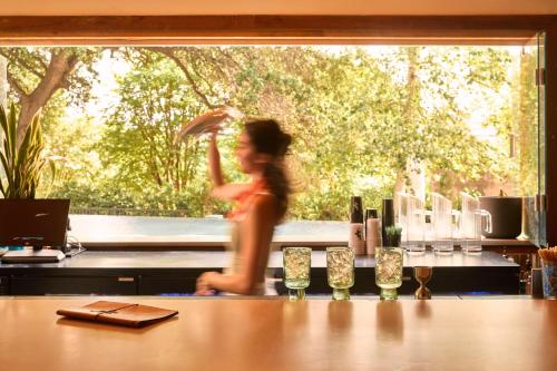 a woman running behind a counter in a kitchen at The LINE Austin in Austin