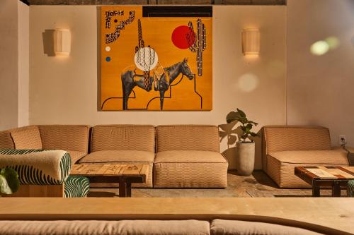 a living room with two couches and a painting of a horse at The LINE Austin in Austin
