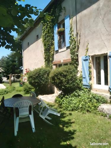 a table and chairs in the yard of a house at Le Gite Des Peyreyres in Lespéron
