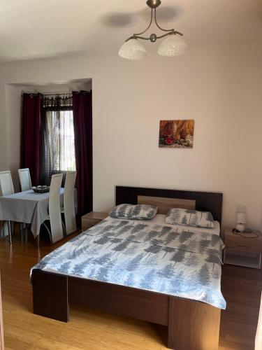 a bedroom with a large bed and a dining table at Roman Gardens Studio Apartment in Risan