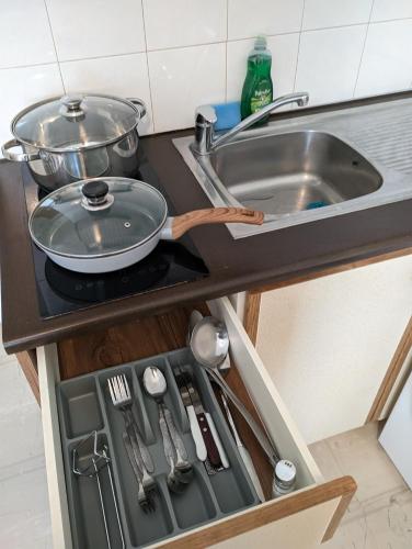 a kitchen counter with a frying pan and a sink at Herakleion center single room in Bendevís