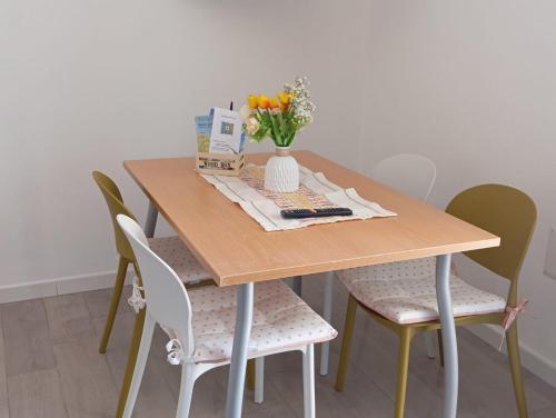 a wooden table with chairs and a vase of flowers at Civico 28 in Badesi