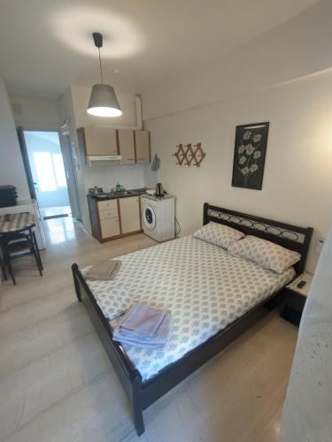 a bedroom with a large bed and a kitchen at Herakleion center single room in Bendevís