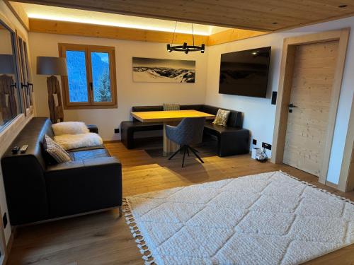 a living room with a couch and a table at Chalet Schneelöwe in Bettelried