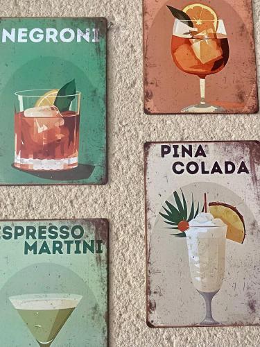 un groupe de quatre panneaux avec différents cocktails dans l'établissement Le petit cocon Figeacois, à Figeac