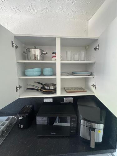 - une cuisine avec un comptoir, un four micro-ondes et une cafetière dans l'établissement Tredegar studio flat, à Tredegar