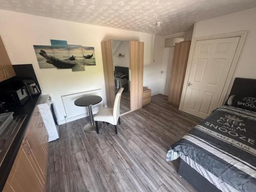 une chambre avec un lit, un bureau et une table dans l'établissement Tredegar studio flat, à Tredegar