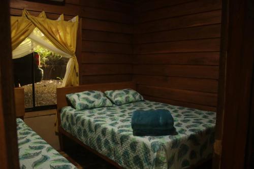 a bedroom with a bed with a blue bag on it at Cabaa Luculuc Garden Forest in San Pedro