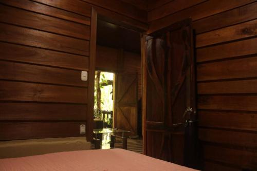 a bedroom with a door open to a room with a bed at Cabaa Luculuc Garden Forest in San Pedro