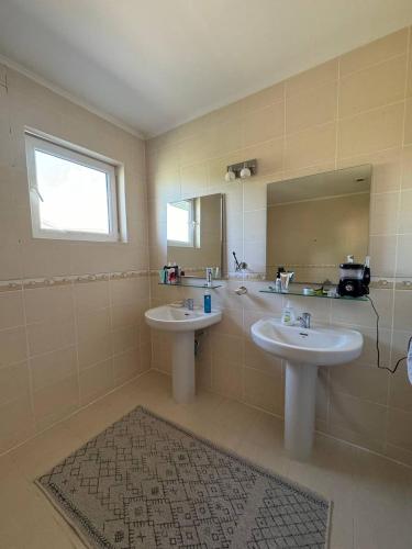 a bathroom with two sinks and a mirror at Family cottage in Bosteri