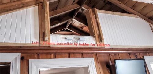 un mur en bois avec un panneau au-dessus de deux portes dans l'établissement Cottage 3 - Pet Friendly - 1 Bedroom / 1 Bath, à Wolfeboro