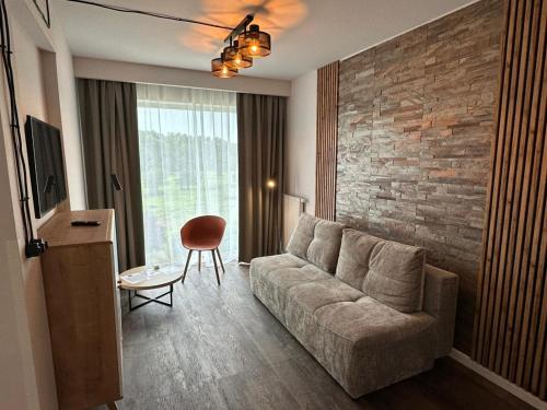 a living room with a couch and a brick wall at Wilanów Residence Apartments in Warsaw