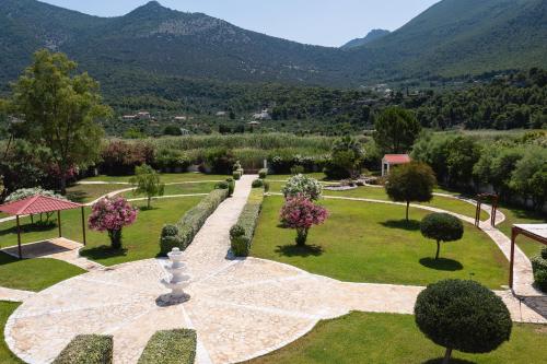 a garden with trees and bushes and mountains in the background at Psatha Villa's in Psatha