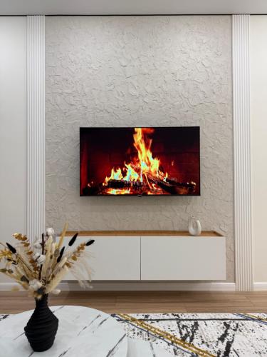 Una chimenea en una sala de estar con fuego. en ESTET Comfort, en Almaty