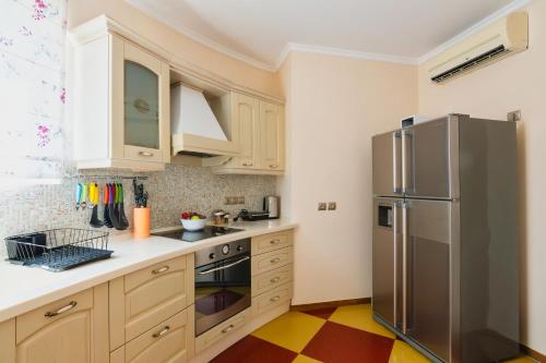 a kitchen with white cabinets and a stainless steel refrigerator at Psatha Villa's in Psatha