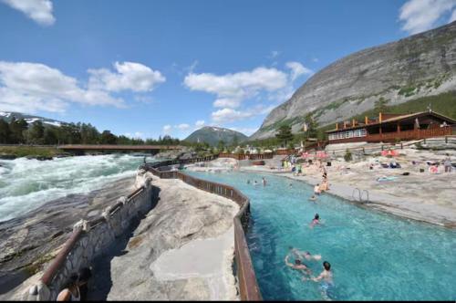 a group of people in a swimming pool next to a river at Signegarden in Skjåk