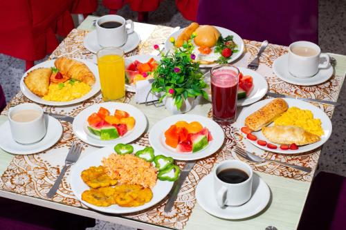 a table with plates of breakfast food on it at Hotel Catedral inn B SAS in Barranquilla