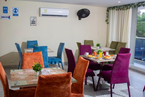 a dining room with tables and purple chairs at Hotel Catedral inn B SAS in Barranquilla