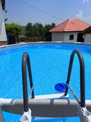 a swimming pool with blue water in a house at Dedina kuća in Gornji Milanovac