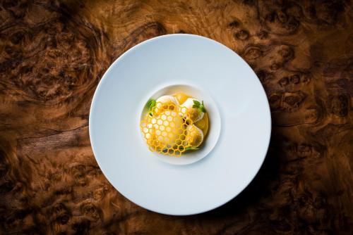 a white plate with a dish of food on a table at Plas Dinas Country House in Caernarfon