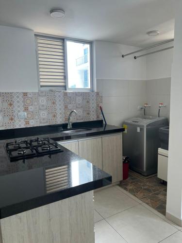 a kitchen with a sink and a stove in it at Apartamento Alejandría in Yopal