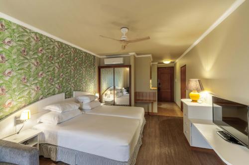 a bedroom with a white bed and a green wall at Pestana Ocean Bay Resort in Funchal