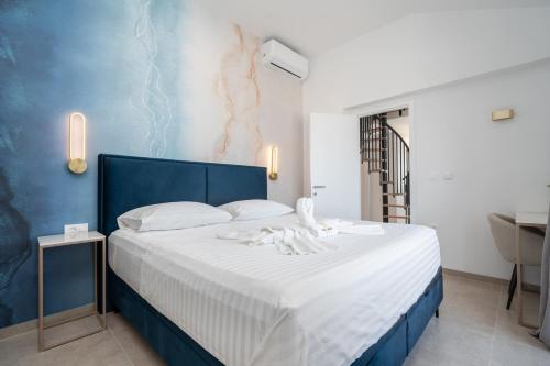 a bedroom with a blue and white bed and a sink at Villa Božica - sea view stone villa with free parking in Makarska