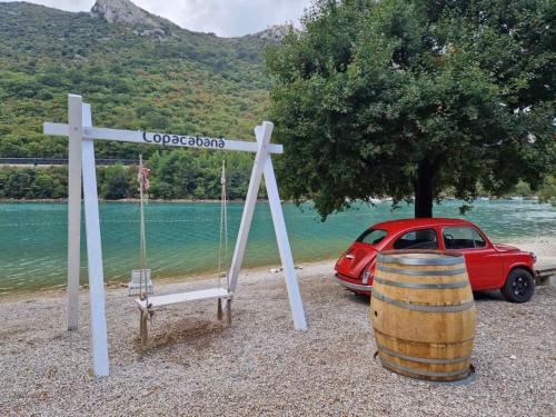 a cross and a red car and a red wine barrel at Apartman Fonovici in Juraši