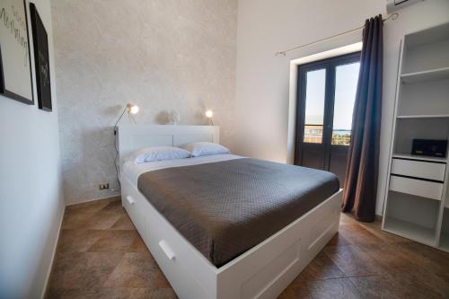 a bedroom with a large bed with a large window at Vista Mare 16 in Siracusa
