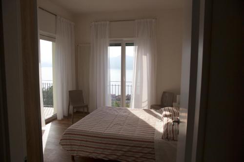1 dormitorio con cama y ventana grande en Villa Paola, en Torri del Benaco