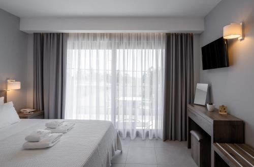 a hotel room with a bed and a large window at Golden Olympus Rooms in Paralia Katerinis