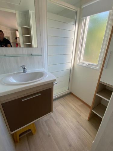 a bathroom with a sink and a mirror at Mobil-Home à Camiers dans un camping 3 étoiles in Camiers