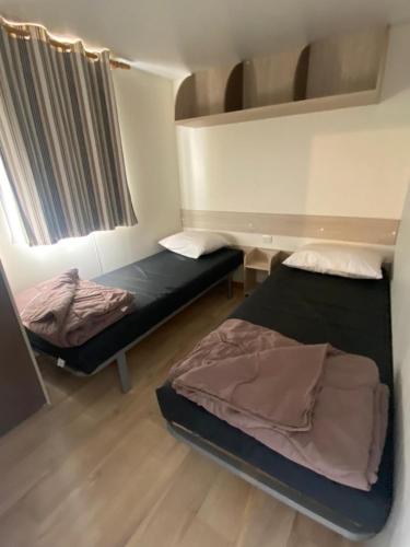 a room with two bunk beds in a room at Mobil-Home à Camiers dans un camping 3 étoiles in Camiers
