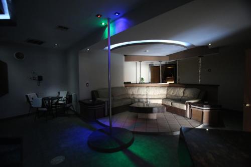 a living room with a couch and a table with a green light at Motel Mediterraneo in Mexicali