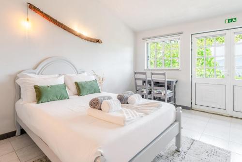 a bedroom with a white bed and a table at Fountain Retreat I Pool, Jacuzzi & Sports Escape in Viana do Castelo