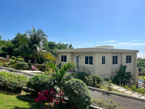 a large white house with plants and flowers at The Indianna Luxury Pool & Spa in Whitehouse