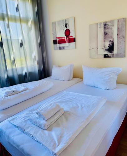 two beds with white sheets and towels on them at Siegener Balkon-Refugium in Plauen