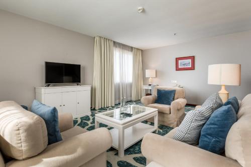 a living room with two couches and a tv at Holiday Inn Porto Gaia by IHG in Vila Nova de Gaia