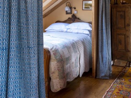 a bedroom with a bed with a blue and white blanket at The Barn in Dartmouth