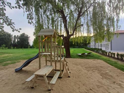 a wooden playground with a slide and a tree at Ca' Allegra in Mogliano Veneto