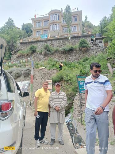 a group of three men standing next to a car at GREEN TARA HOMESTAY Keylong in Kyelang