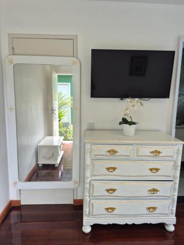 a dresser with a mirror and a tv on top at MF Flat in Ilhéus