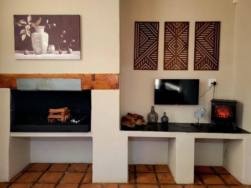 Una televisión o centro de entretenimiento en Sandstone Escape Guesthouse