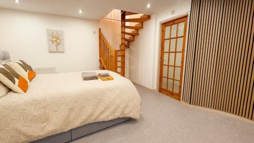 a bedroom with a large bed and a staircase at 1-Bed Flat in Central Northampton in Northampton